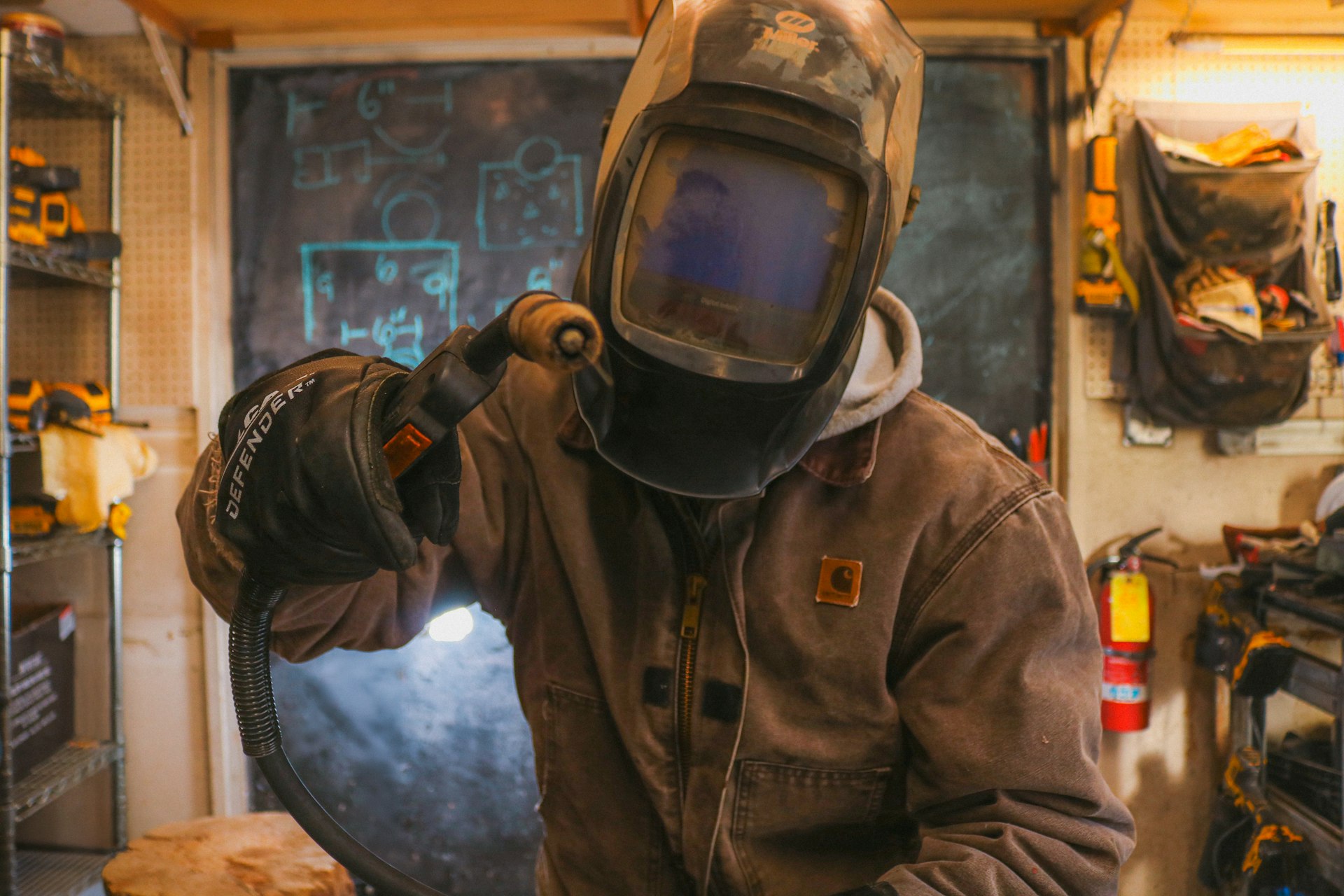 A man in a welding helmet working on a piece of metal